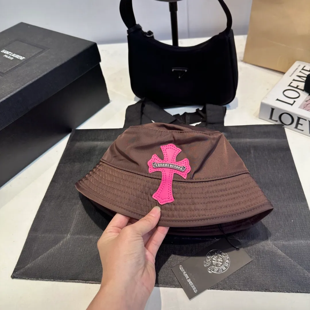 P70 𝐶ℎ𝑟𝑜𝑚𝑒 𝐻𝑒𝑎𝑟𝑡𝑠 Crow Heart Chocolate Barbie Pink Cross Leather Brand Horseshoe Roll Sleeves Sanskrit Letters Fisherman Hat Sun Hat